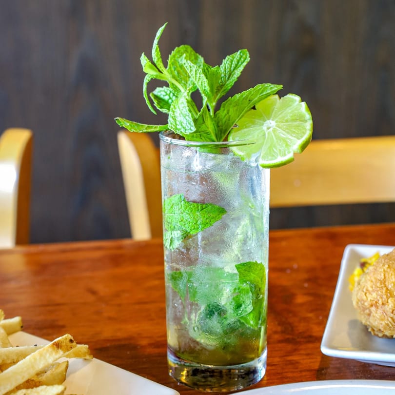 Refreshing mojito with mint and lime, alongside fries and a fried chicken sandwich at PoPo Family Restaurant.